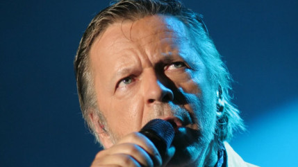 Renaud accompagné par deux fans qui l'aident au quotidien